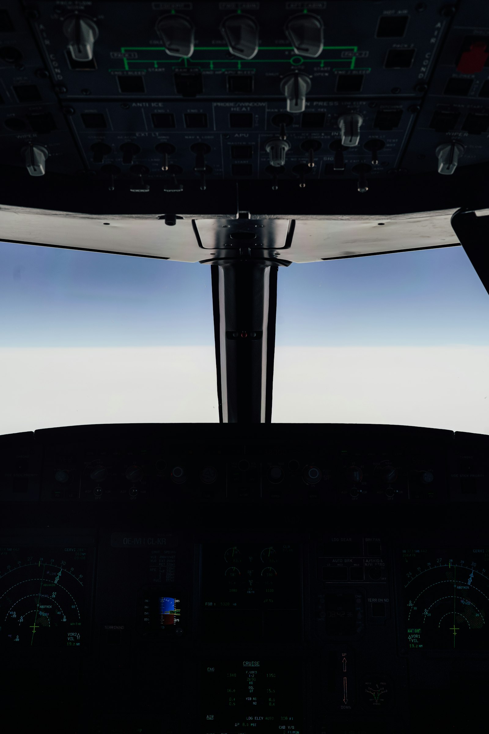 View from a small aircraft cockpit above a layer of clouds