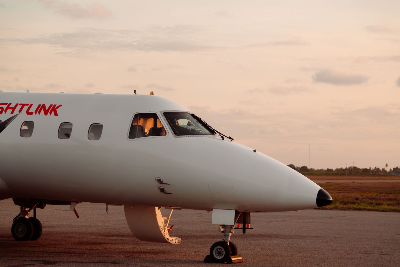 Private jet parked on an airport tarmac during golden hour